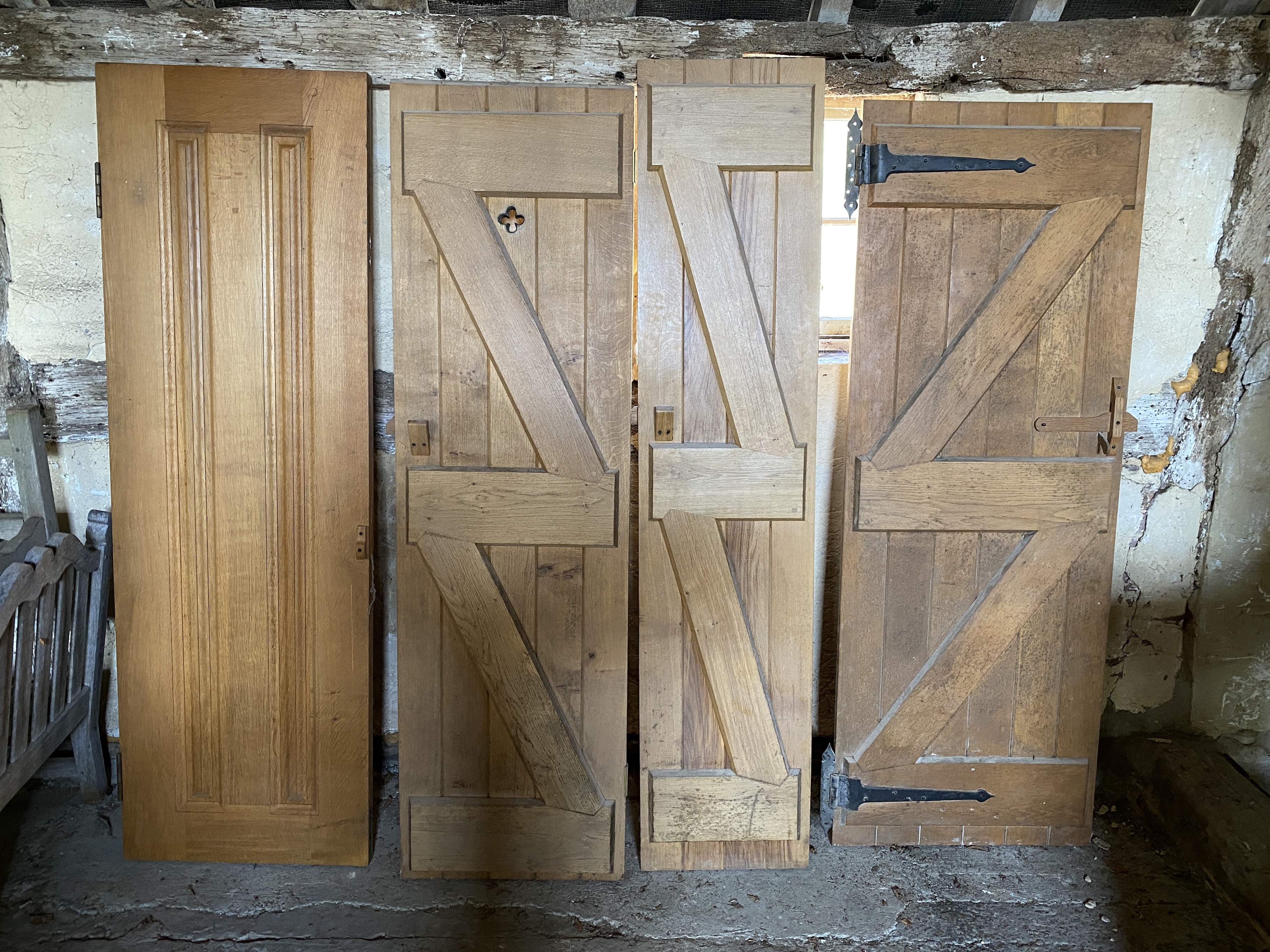 Three solid oak ledged and braced doors, 210 x 58.5cm; 204 x 44.5cm and 95 x 72cm, and a double sided panelled solid oak door, 200 x 64cm (4)